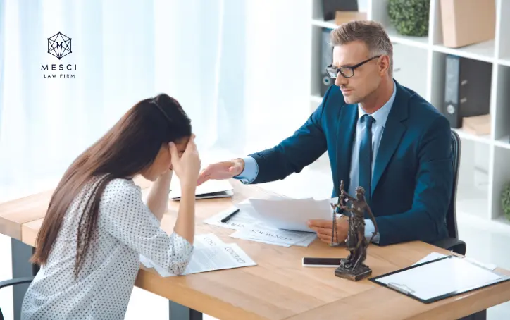A woman receiving legal counseling from a lawyer during a divorce process, with documents and a scale of justice emblem on the table.